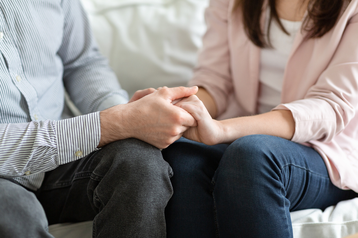 Married couple holding each other hands during family therapy